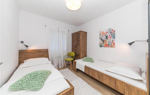 1 dormitorio con 2 camas y 1 silla en Beautiful Home In Jadrija With 4 Bedrooms, Wifi And Outdoor Swimming Pool en Jadrija