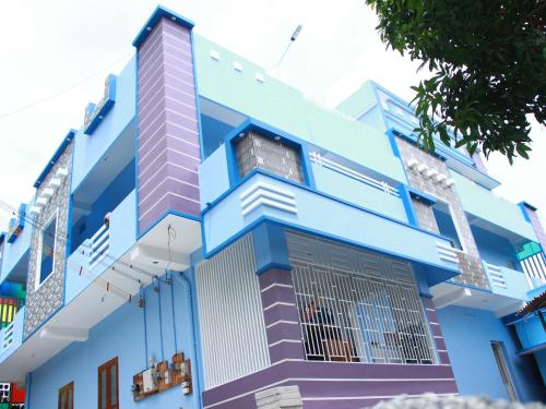 a blue building with a window at Countryside inn in Tiruvankod