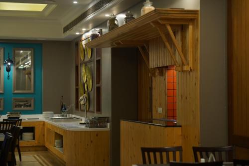 a kitchen with a sink and a counter with chairs at Park Plaza Jodhpur in Jodhpur