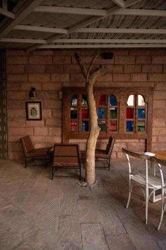 a room with a table and chairs and a tree at Park Plaza Jodhpur in Jodhpur