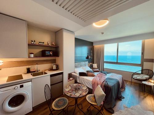 1 dormitorio con 1 cama, lavamanos y lavadora en C Tower Apartments en Netanya