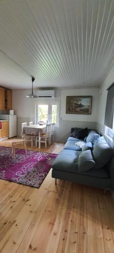 ein Wohnzimmer mit einem blauen Sofa und einem Tisch in der Unterkunft Jämsän Himoksen torppa Savusaunalla in Jämsä