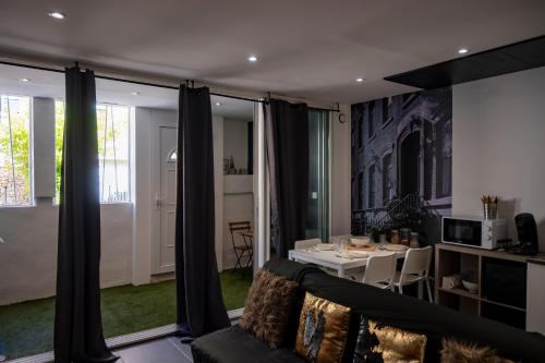 salon z kanapą i stołem w obiekcie Superbe appartement avec Patio w mieście Nîmes