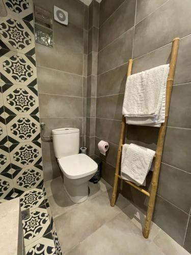 a bathroom with a toilet and towels on a wall at Xenios Hotel in Pefkochori