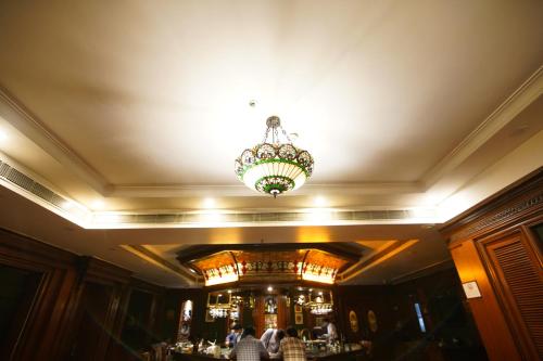 a restaurant with a chandelier and a bar at Park Plaza Jodhpur in Jodhpur