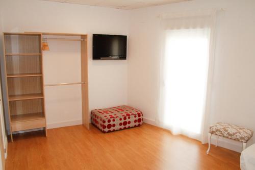 um quarto com uma televisão e um repousa-pés num quarto em Antich Apartment Deltebre em Deltebre