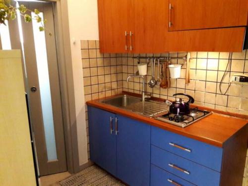 a kitchen with blue cabinets and a sink at Ortigia House in Syracuse