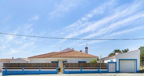 a white house with a fence in front of it at Comporta Center Villa in Comporta