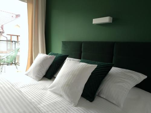 a bed with black and white pillows and a window at Apartamenty Mistral in Jastarnia