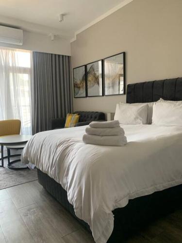 Pretoria的住宿－Entire Studio Apartment @MenlynMaine，卧室配有一张带白色床单和枕头的大床。