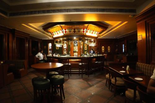 a bar in a restaurant with tables and chairs at Park Plaza Jodhpur in Jodhpur
