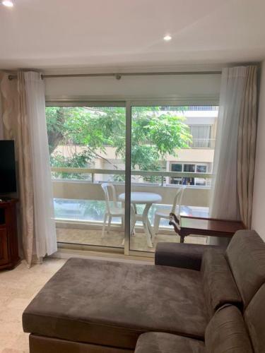 a living room with a couch and a large window at Le Roxane 2 bedroom apartment in the city-center of Antibes in Antibes