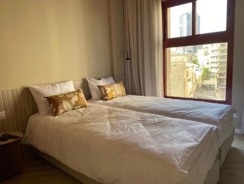 łóżko w pokoju z dużym oknem w obiekcie GoodHouse 401 - Beautiful Flat in Center of Jerusalem w Jerozolimie