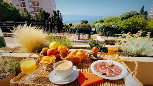 a table with a breakfast of fruit and a cup of coffee at Sun Beach in Ajaccio