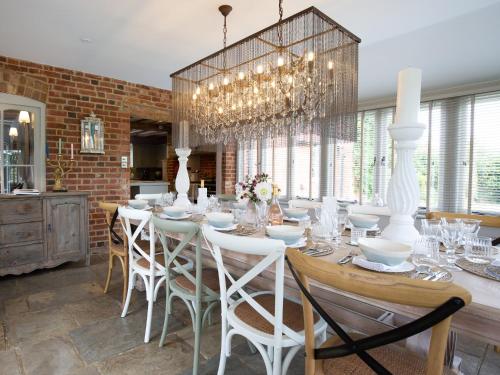 a dining room with a long table and white chairs at Beecham Farmhouse in Stratford-upon-Avon
