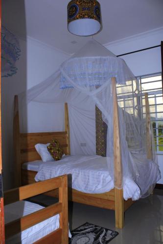 1 dormitorio con cama de madera y dosel en IOP Cabin Ilula, 