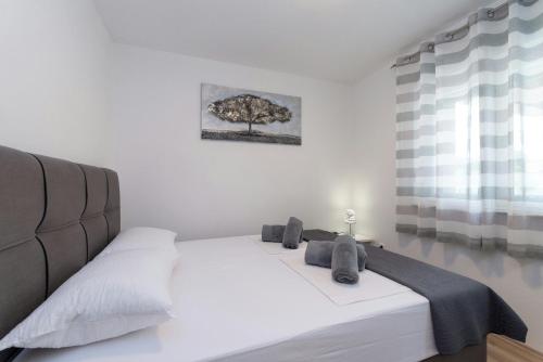 een slaapkamer met een wit bed met een boom aan de muur bij Villa Zrilic ZadarVillas in Perušić Benkovački