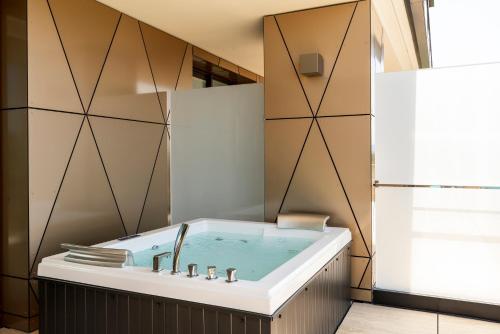 a bathroom with a bath tub with a sink at The Promenade Luxury Wellness Hotel in Riccione