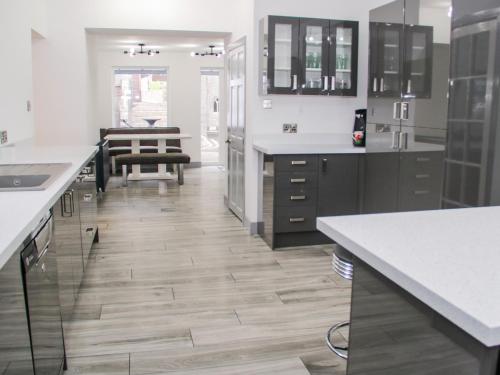 eine Küche mit weißen Arbeitsplatten und Holzböden in der Unterkunft The Moores in Prestatyn