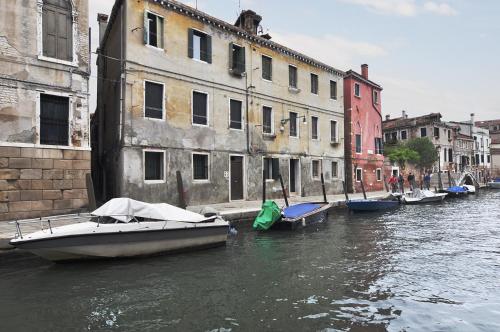 a group of boats docked in a canal with buildings at Al Mascaron Ridente in Venice