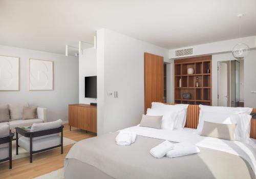 ein weißes Schlafzimmer mit einem großen Bett und einer Couch in der Unterkunft Amazing Seafront Croatian Villa 5 Bedrooms Villa Primosten Pearl in Primošten