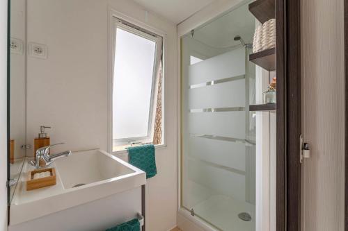 een badkamer met een wastafel en een glazen douche bij Camping La Forêt in Saint-Jean-de-Monts