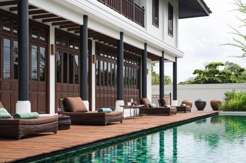 a resort with a swimming pool and chairs next to a building at Siri Sala Private Thai Villa in Bangkok