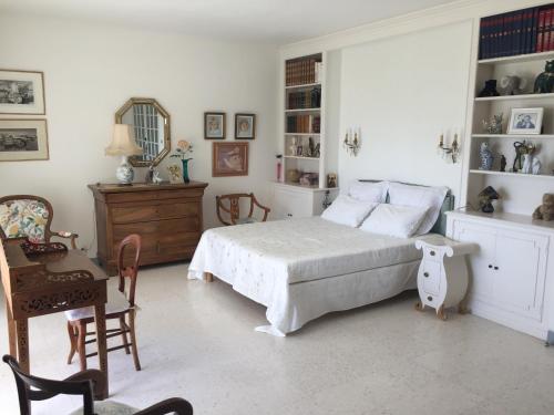 um quarto com uma cama, uma secretária e uma cadeira em Chez Mamouska em Cassis