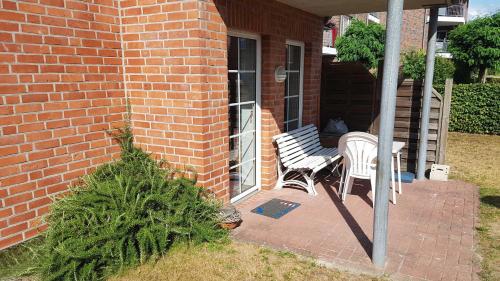 a brick house with a bench and a table on a porch at Ferienwohnung Mueller_ 15121 in Leer