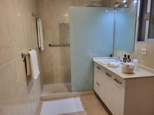 y baño con ducha, lavabo y espejo. en Cozy apartment next to Hard Rock Hotel, en Marbella