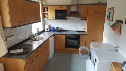 a small kitchen with a sink and a stove at Ferienwohnung Mueller_ 15121 in Leer