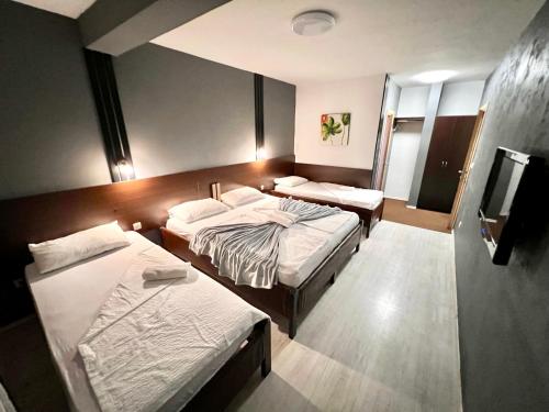 モスタルにあるHotel & Spa Villa Luxeのベッド2台とテレビが備わるホテルルームです。
