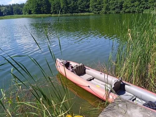 a boat sitting in the water on a lake at Domki nad Szelągiem in Kątno