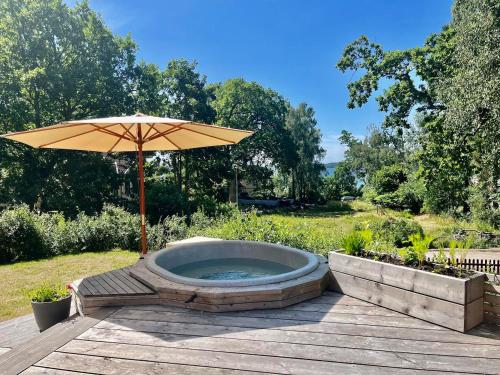 - un bain à remous avec un parasol sur la terrasse dans l'établissement Villa Rye Street Kolmården, à Kolmården
