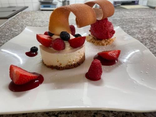 a dessert with strawberries and blueberries on a white plate at Hôtel de la Pointe de Mousterlin in Fouesnant