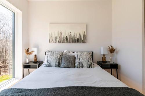 a bedroom with a large bed with two night stands at trähus tremblant in La Conception