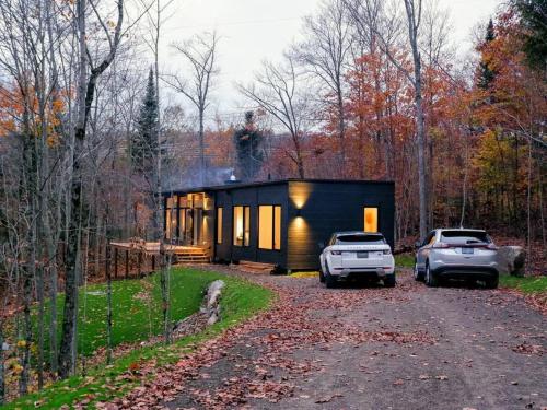a house with two cars parked in front of it at trähus tremblant in La Conception
