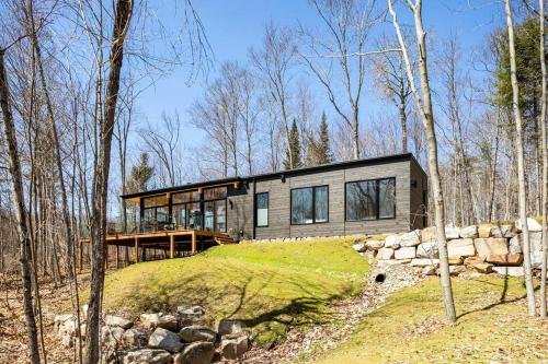 a house on top of a hill in the woods at trähus tremblant in La Conception