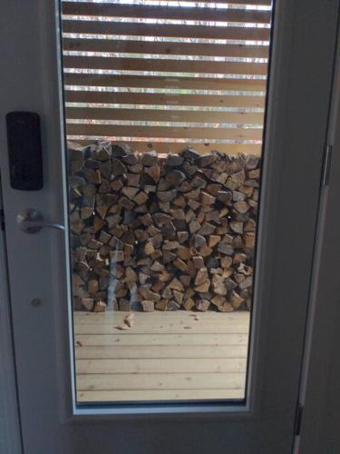 a glass door with a pile of fire wood at trähus tremblant in La Conception