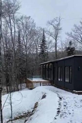 a house with snow on the ground in front of it at trähus tremblant in La Conception