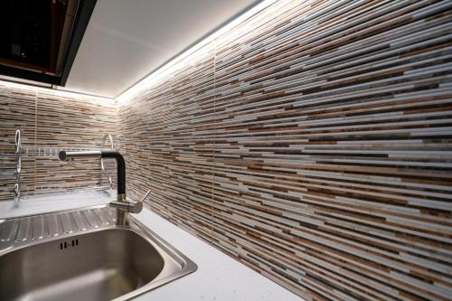 uma cozinha com um lavatório e uma parede de tijolos em Keramikos metro st luxury studio for 2 by MPS em Atenas