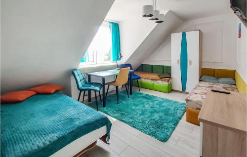 コウォブジェクにあるBeautiful Apartment In Kolobrzeg With 2 Bedrooms And Wifiのベッドルーム1室(ベッド1台、テーブル、椅子付)