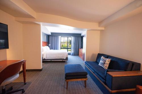 a hotel room with a bed and a couch at Courtyard by Marriott Philadelphia Springfield in Springfield