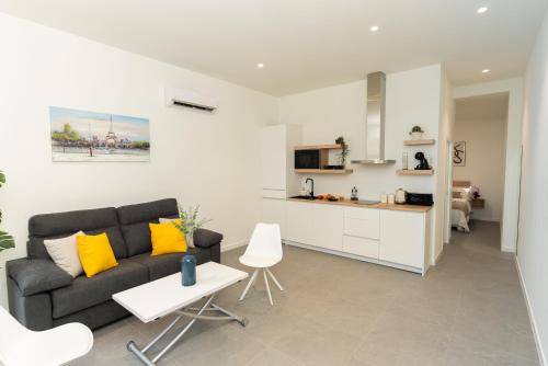 a living room with a couch and a kitchen at Lofts Jumaral - La Magdalena in Córdoba