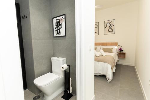 a bathroom with a toilet and a bed at Lofts Jumaral - La Magdalena in Córdoba