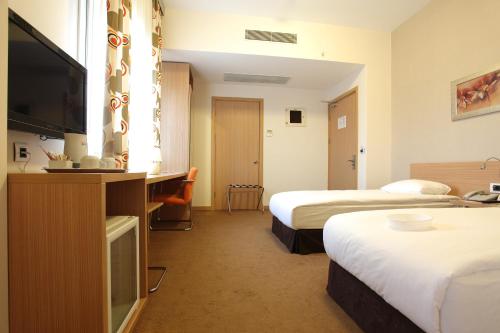 a hotel room with two beds and a flat screen tv at Orucoglu Oreko Hotel in Manisa