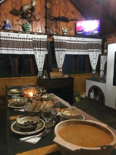 een tafel met borden en kommen met eten erop bij Casa Gabriel in Frumosu