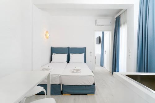 um quarto branco com uma cama num quarto em Filoxenia Luxury Apartments em Potos