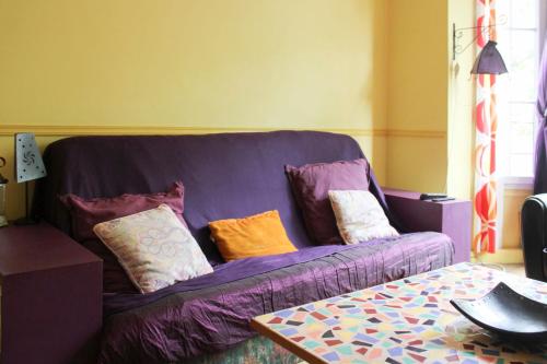 - un canapé violet avec des oreillers dans le salon dans l'établissement Cozy love nest near Stade de France, à Paris