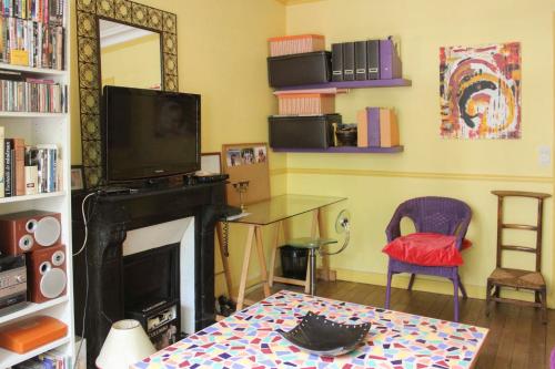 un salon avec une cheminée et une télévision dans l'établissement Cozy love nest near Stade de France, à Paris